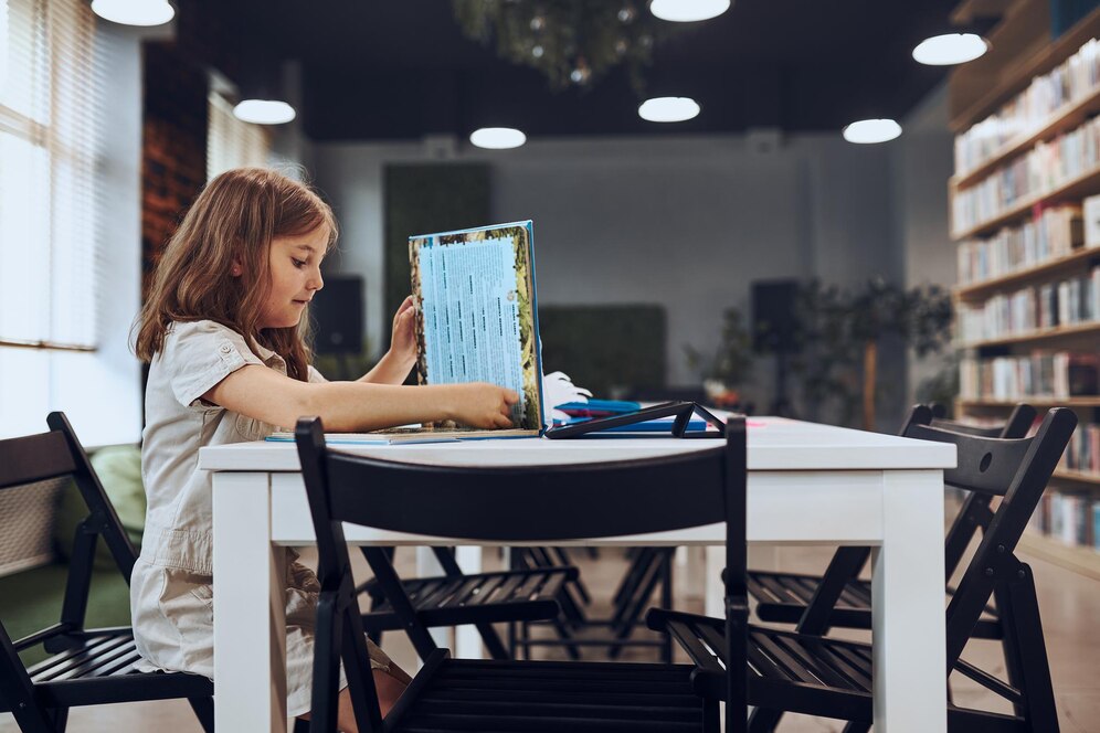 schoolgirl-doing-puzzle-reading-book-school-library-smart-girl-learning-from-book_1048944-14088496